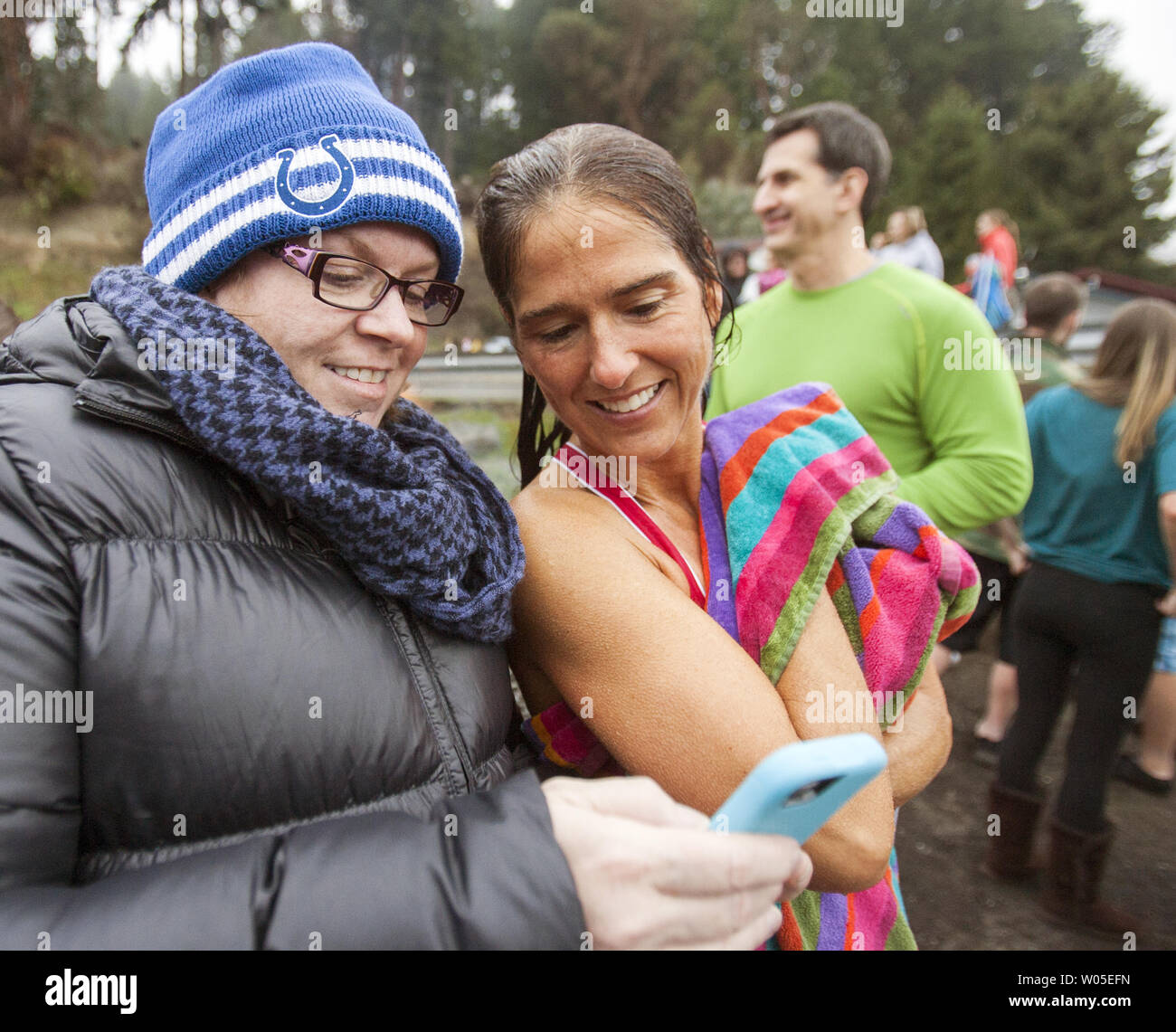 Sarah Whalen , left, shows Jen Townsend a video she took of  Jen hurling herself off the bridge into the Burley Lagoon during the 30th annual Polar Bear in  Olalla, Washington on January 1, 2014. Over over a period of three hours more than 450 hardy participants jumped into the frigid waters for the annual Polar Bear Plunge into the chilly lagoon waters to join in on the annual New Year's Day Tradition.   UPI /Jim Bryant Stock Photo