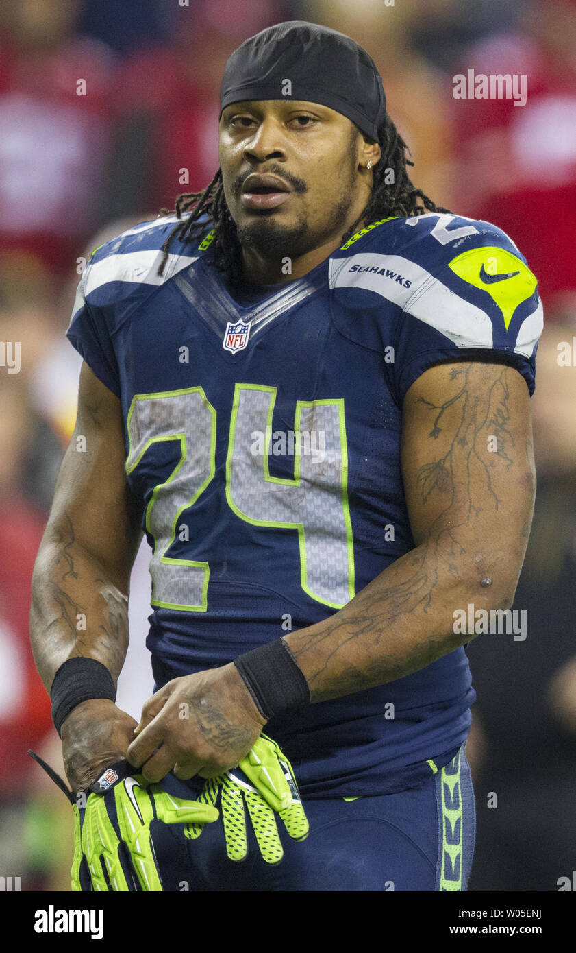 Seattle Seahawks running back Marshawn Lynch (24) dons his gloves during an  injury time out during the NFL Championship Game against the San Francisco  49ers at CenturyLink Field in Seattle, Washington on