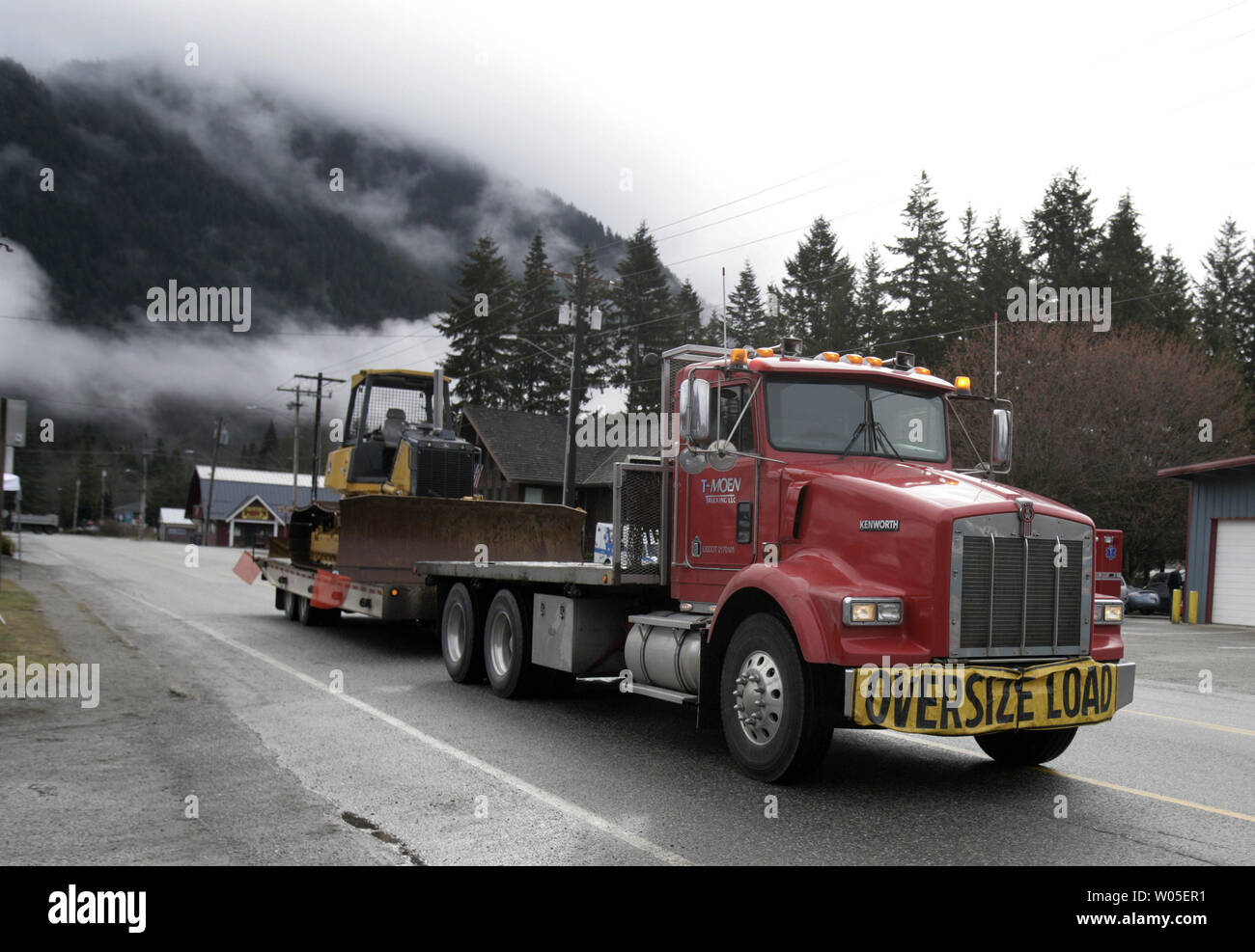 Heavy equipment is transported down Hwy 320 that will be used in search and rescue efforts in Darrington, Washington on March 27, 2014. Rescue efforts continue in the aftermath of Saturday's mudslide that buried the nearby town of Oso.  Some 25 bodies have been discovered with more than 90 missing from the tragic mudslide.  UPI/Jim Bryant Stock Photo