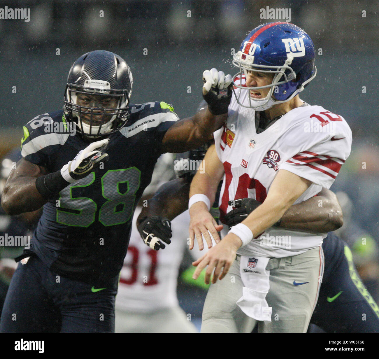 New York Giants quarterback Eli Manning (10) takes a hit from Seattle Seahawks Kevin Pierre-Louis (58) and K.J. Wright  (50) at CenturyLink Field in Seattle, Washington on November 9, 2014. The Seahawks  beat the Giants 38-17.     UPI/Jim Bryant Stock Photo