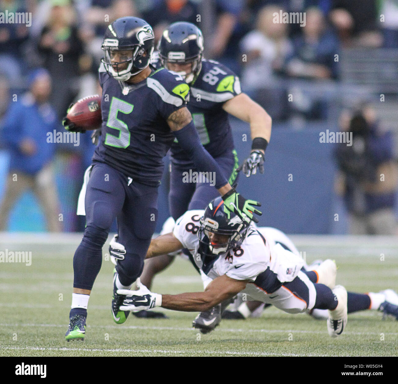 Seattle Seahawks kick off returner B.J. Daniels is tripped up by Denver  Broncos Curtis Marsh after a 35-yard return during the second quarter at  CenturyLink Field on August 14, 2015 in Seattle