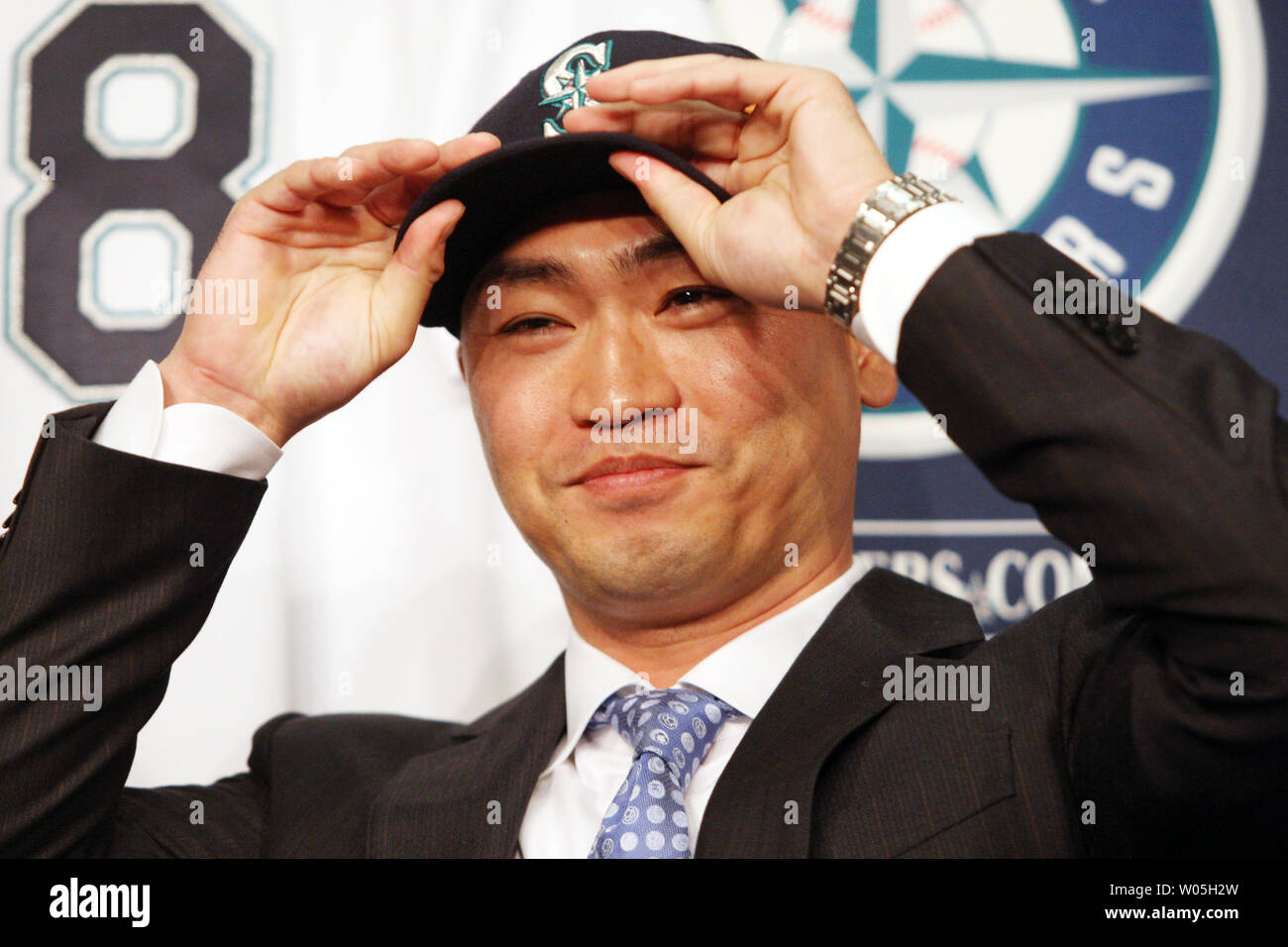 Norichika AokI  tries on his  Mariners Cap during introduction to the press. The Mariners have signed free agent outfielder Norichika AokI to a one-year contract with a vesting mutual option for the 2017 season at SAFECO Field on December 3, 2015 in Seattle.    Photo by Jim Bryant/UPI Stock Photo
