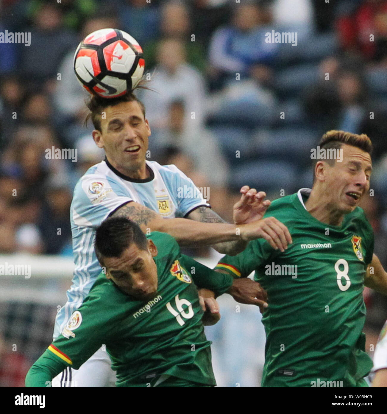 Argentina's Lucas Biglia, center, heads the ball away from Bolivia defenders Martin Smedberg-Dalence (8) and Cristhian Machado (16) in a 2016 Copa America Centenario soccer match at CenturyLink Field in Seattle, Washington on June 14, 2016.  Argentina beat Bolivia 3-0.   Photo by Jim Bryant/ UPI Stock Photo