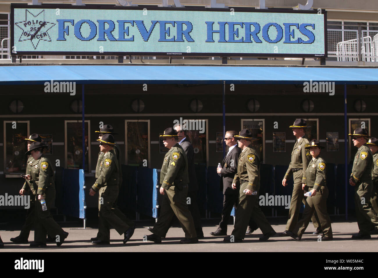 Members of the San Francisco Sheriff's Department walk by a sign honoring the four Oakland Police officers, in Oakland, California on Friday, March 27, 2009. Thousands of police officers gathered for the funeral of the Oakland Police officers who were fatally shot in the line of duty. (UPI Photo/Bob Larson) Stock Photo