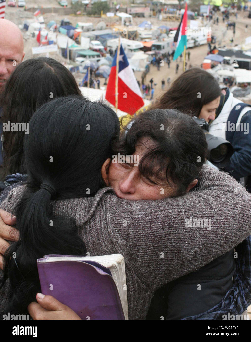 Relatives hug as preparations continue to rescue the 33 trapped miners at San Jose Mine, Chile on October 11, 2010.   If all goes well, officials say the first miners will be brought up in a few days via a 20-minute ride in a rescue capsule more than 2,000 feet below the surface.   The miners have been trapped for more than two months.   UPI/Sebastian Padilla Stock Photo