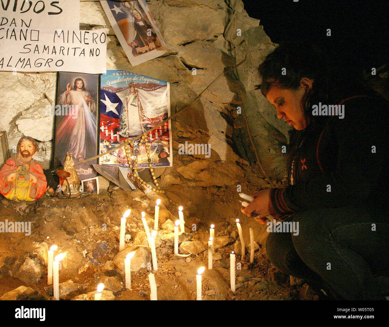 Relatives light candles near religious symbols as preparations continue to rescue the 33 trapped miners at San Jose Mine, Chile on October 12, 2010.   If all goes well, officials say the first miners will be brought up within a day via a 20-minute ride in a rescue capsule more than 2,000 feet below the surface.   The miners have been trapped for more than two months.   UPI/Sebastian Padilla Stock Photo