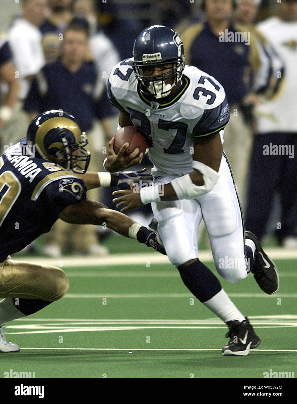 Seattle Seahawks running back Shaun Alexander rushes past St. Louis Rams Pisa Tinoisamoa for a first down at the Edward Jones Dome in St. Louis on Decmber 14, 2003. Alexander rushed for 126 yards on 25 carries with 1 touchdown as the Rams defeated the Seahawks 27-22.  (UPI Photo/Scott Rovak) Stock Photo