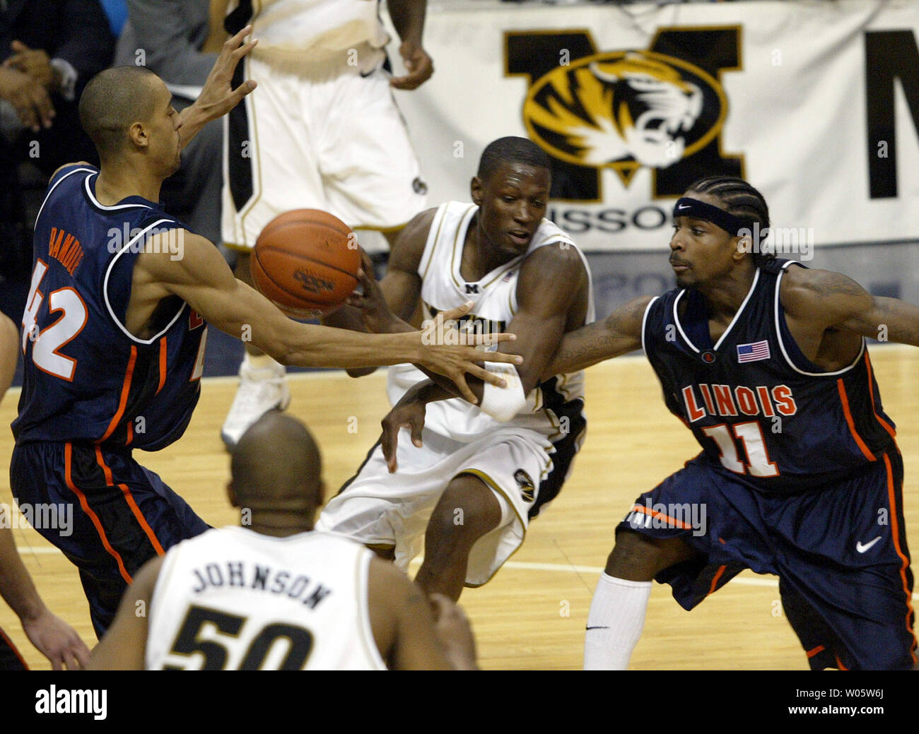 University of Missouri's Jimmy McKinney (C) loses control of the basketball in front of University of Illinois' Brian Randle (L) and Dee Brown (R) in the second half of the Annual Braggin Rights Game at the Savvis Center in St. Louis on December 23, 2003. (UPI Photo/Bill Greenblatt) Stock Photo