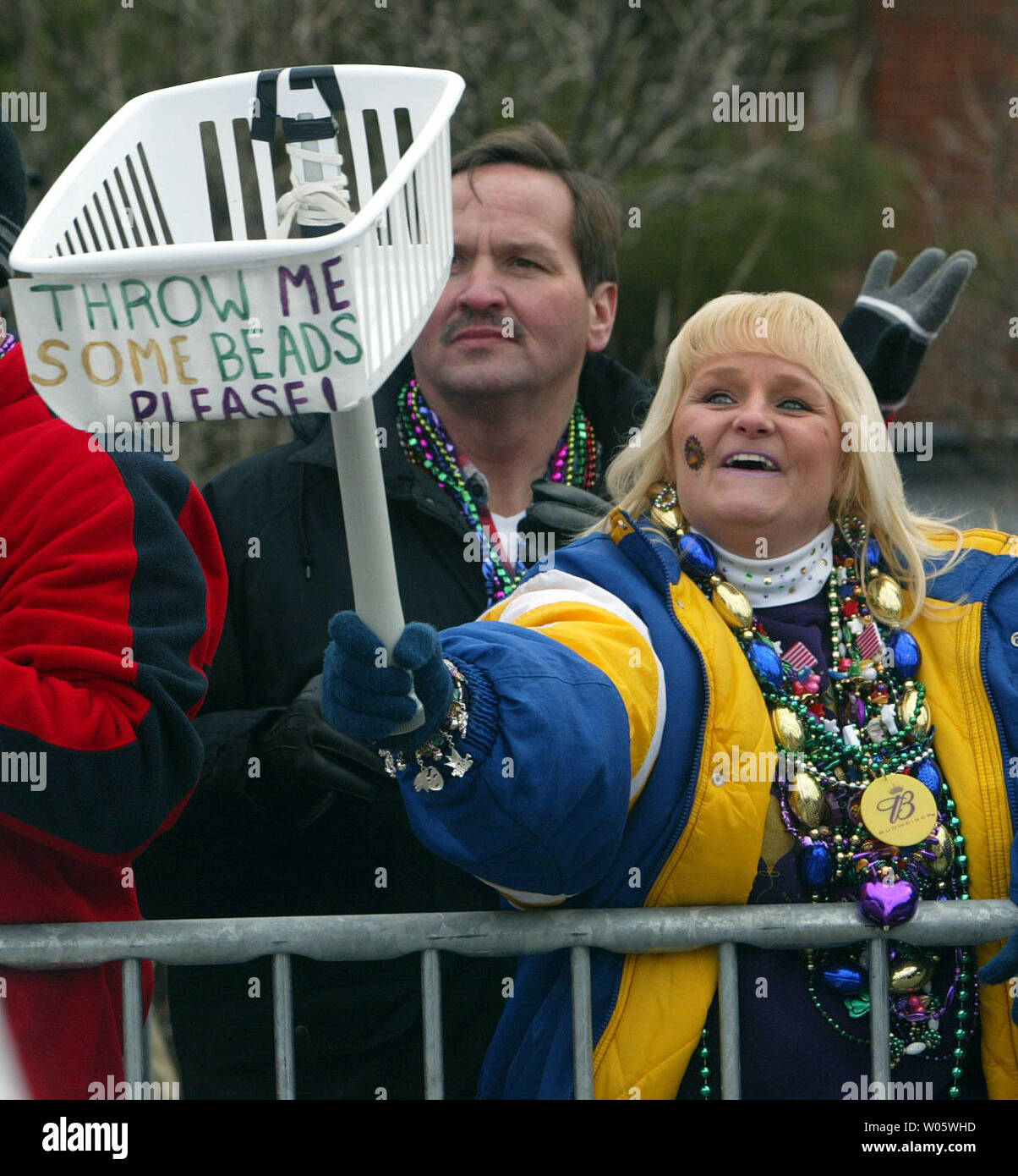Kim Dodson of St. Louis uses a basket to catch beads during the St