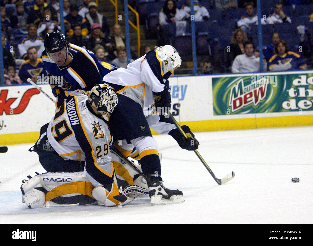 Nashville Predators goaltender Tomas Vokoun (29) is partically screened as teammate Mark Eaton stops the puck while St. Louis Blues Brian Savage tries to skate in during the first period at the Savvis Center in St. Louis on March 11, 2004 (UPI Photo/Bill Greenblatt) Stock Photo