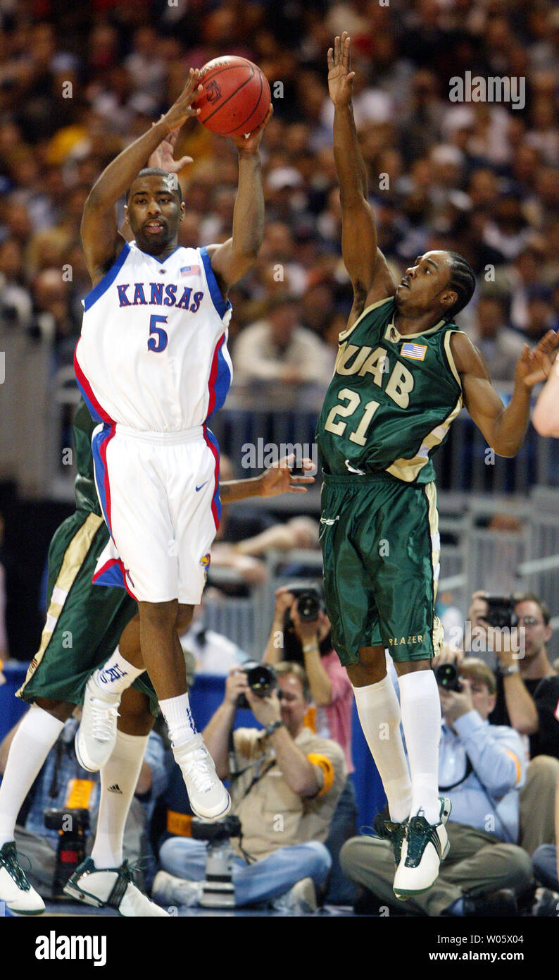 Kansas' Keith Langford (5) looks to pass the basketball as Alabama- Birmingham's Tony Johnson tries to defend in the first half, during their NCAA Regional game at the Edward Jones Dome in St. Louis on March 26, 2004.   (UPI Photo/Bill Greenblatt) Stock Photo
