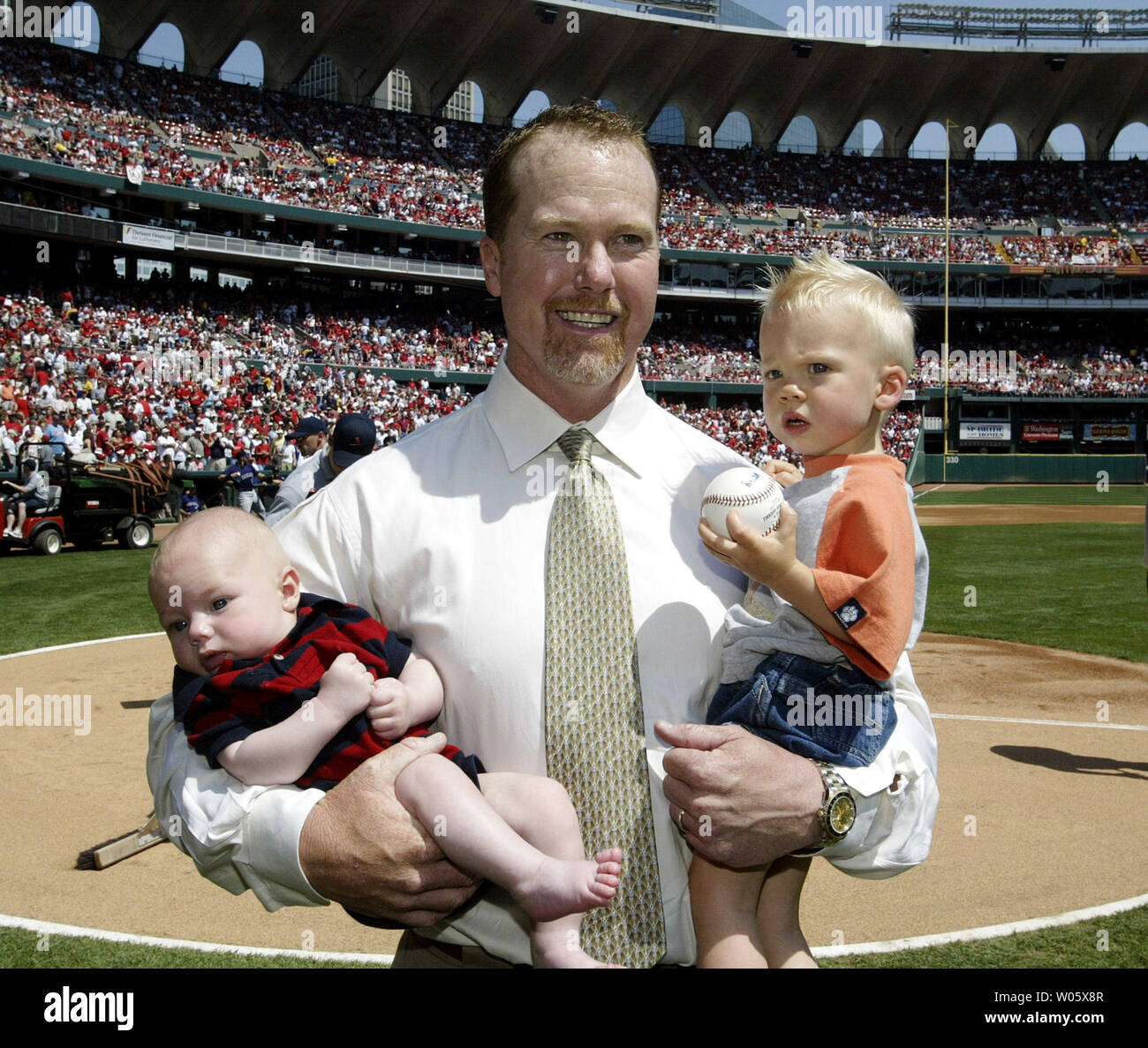 Former St. Louis Cardinals slugger Mark McGwire holds sons three-month-old  Mason (L) and 18 month -old Max during an appearance at Busch Stadium in  St. Louis on April 17, 2004. McGwire returned