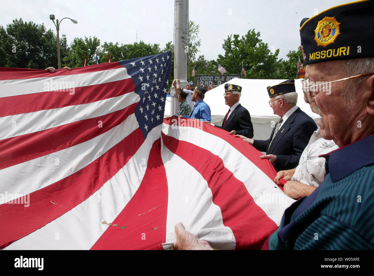 World War II veterans hold an oversized American Flag as it is raised ...