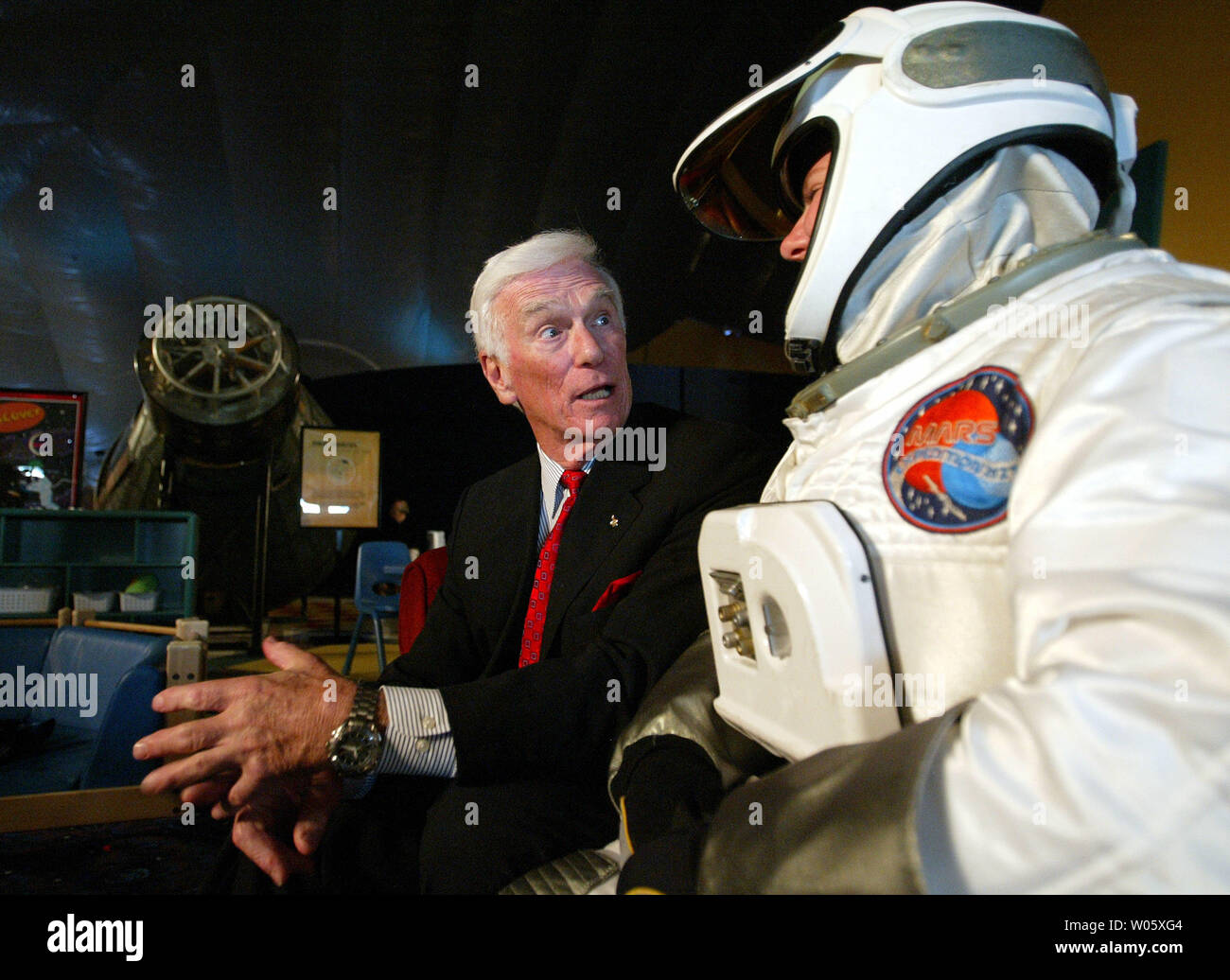 Astronaut Eugene Cernan (L) talks with Hilary Letcher, a gallery assistant dressed as a spaceman, during the opening of the Space Exhibit at the St. Louis Science Center in St. Louis on June 3, 2004. Cernan, the last man to walk on the moon, was on hand to kick off the opening which displays the history of space travel and how it has shaped the future destiny in the universe. (UPI Photo/Bill Greenblatt) Stock Photo