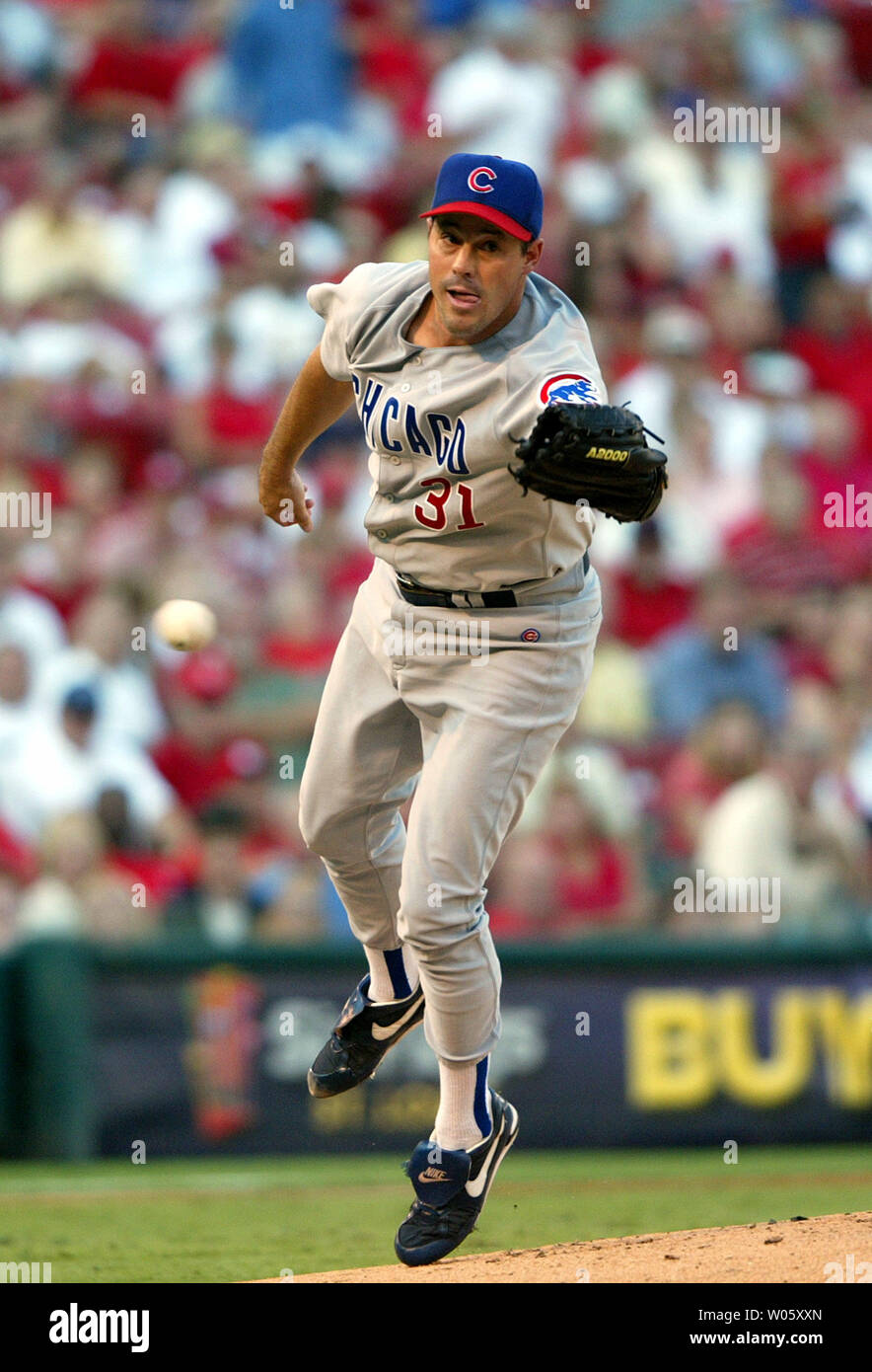 Chicago Cubs pitcher Greg Maddux reaches out but misses the ball off the bat of St. Louis