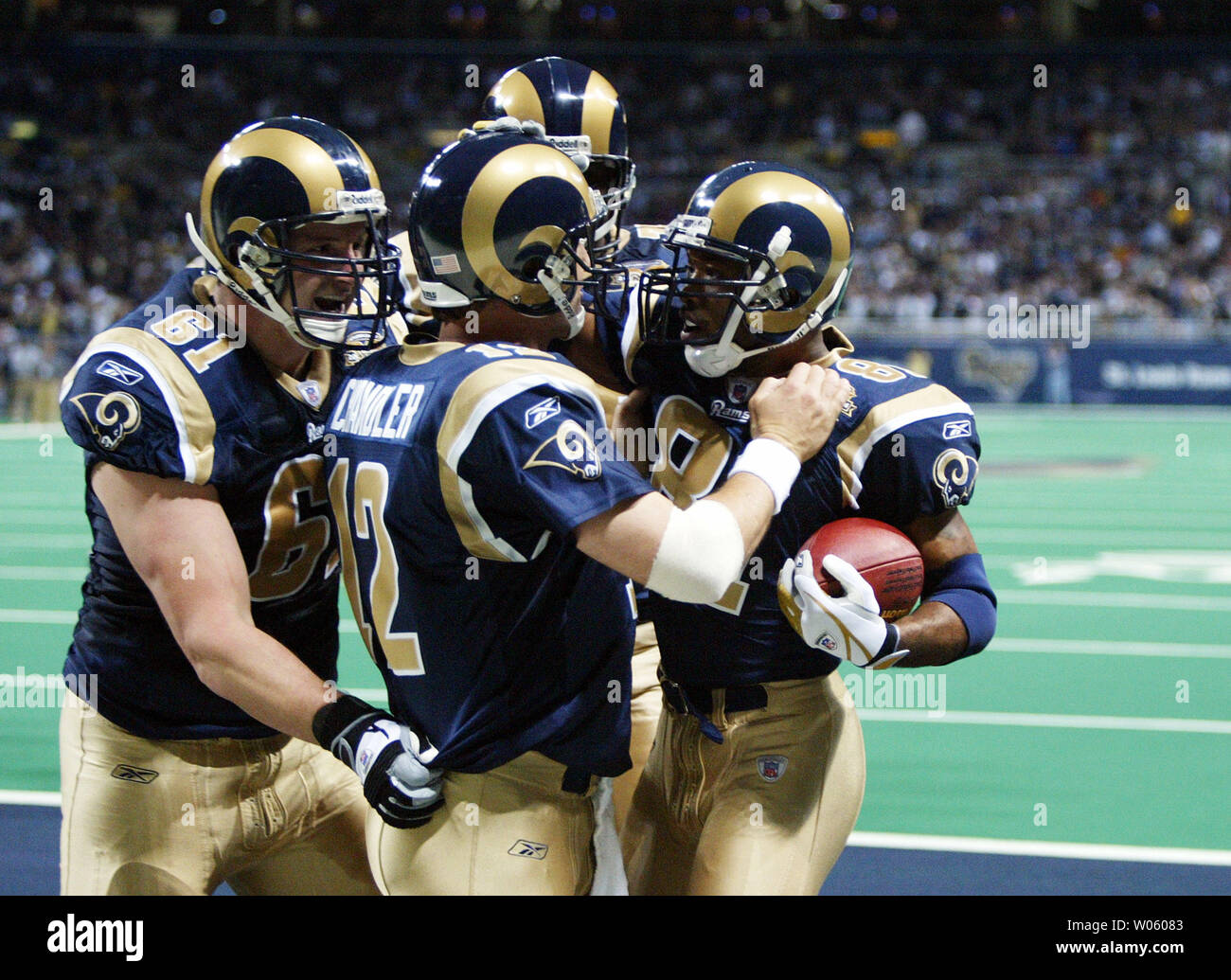 St. Louis Rams quarterback Chris Chandler (12) and Tom Nutten (61) congratulate Torry Holt (R) after Holt caught a pass for a touchdown in the second quarter against the San Francisco 49er's at the Edward Jones Dome in St. Louis on December 5, 2004. (UPI Photo/Bill Greenblatt) Stock Photo