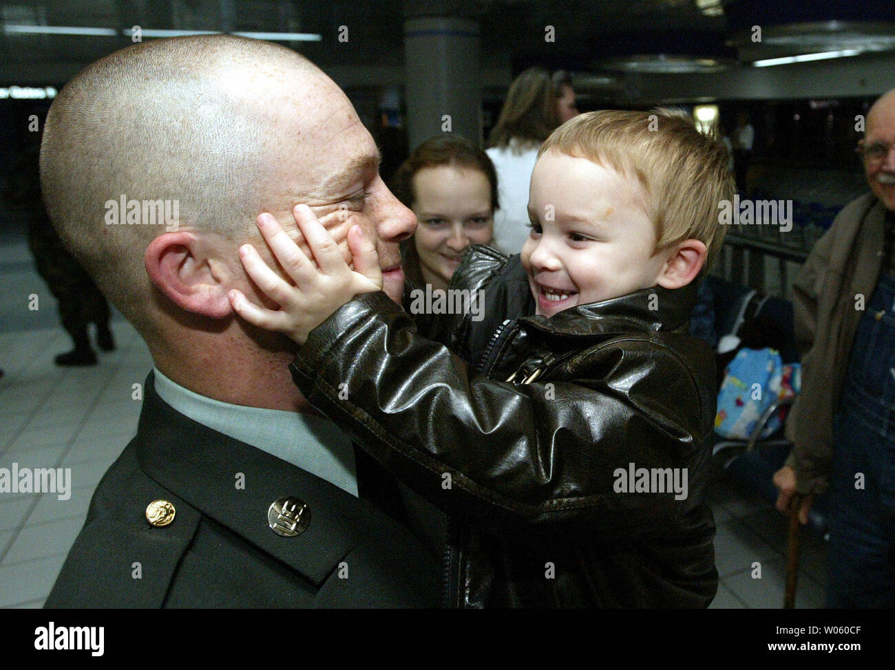 Two year-old James touches dad Damion Helms hairless face as the two are reunited  at Lambert-St. Louis International Airport during Exodus in St. Louis on December 18, 2004. Helms, stationed at Ft. Seal, OK has been away at training for three weeks, only to return without his beard. Over four thousand soilders from Fort Leonard Wood and other training facilities, pass through the airport on their way home for the holidays. UPI Photo/Bill Greenblatt) Stock Photo