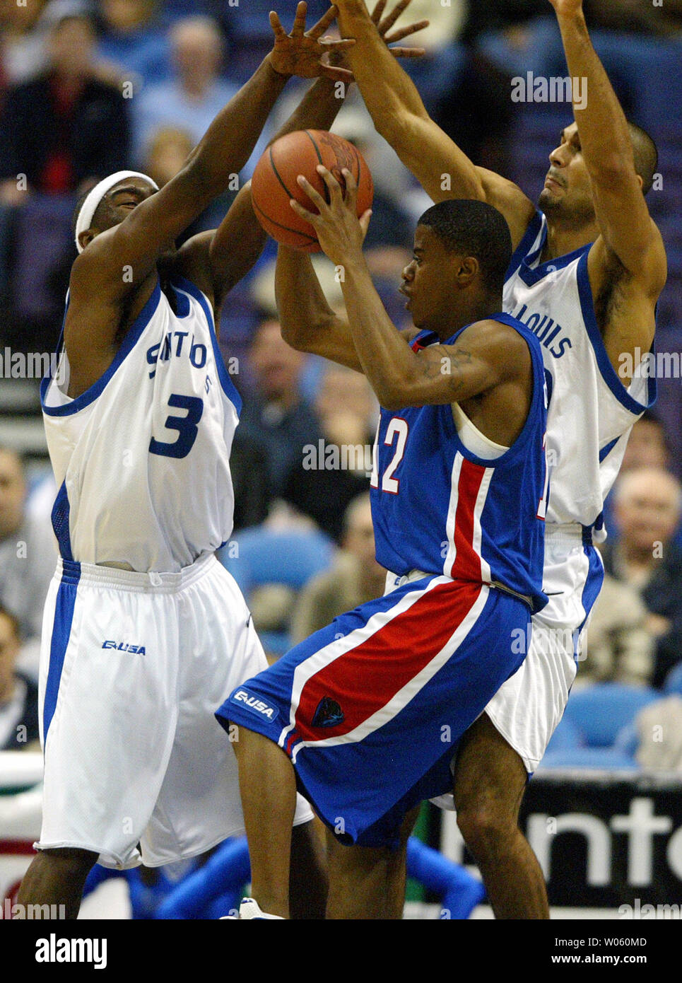 Saint Louis University Billikens Danny Brown (L) and Izik Ohanon (R) put the pressure on DePaul Blue Demons Cliff Clinkscales in the first period at the Savvis Center in St. Louis on February 6, 2005. (UPI Photo/Bill Greenblatt) Stock Photo