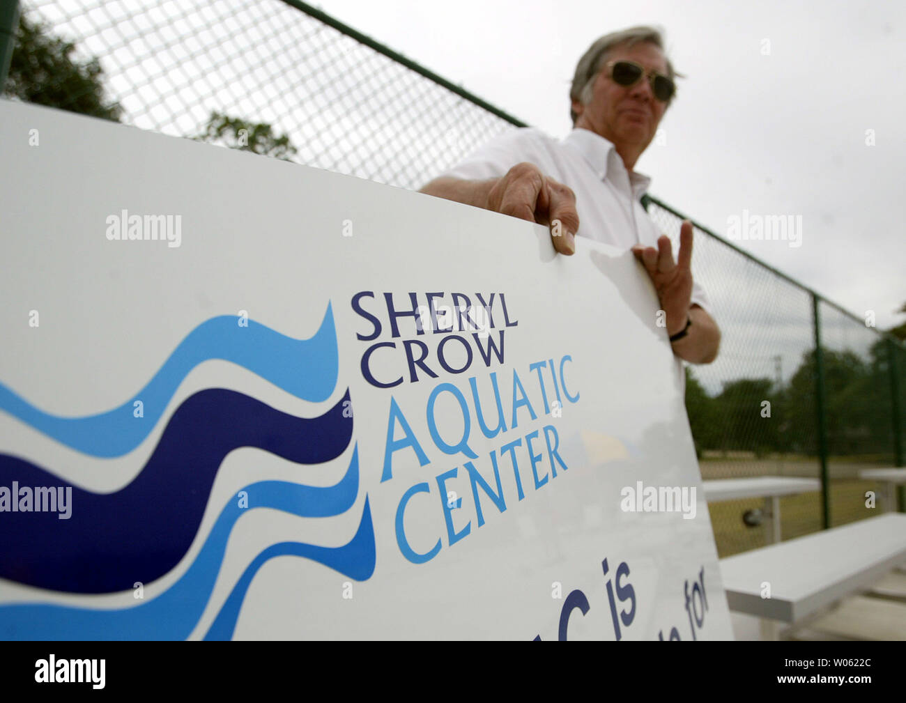 Volunteer Doug Milburn carries a sign to be installed at the new Sheryl