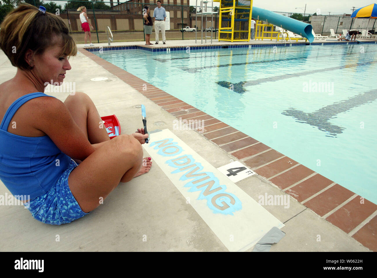 Melinda Harris paints a NO DIVING sign in the shallow end of the new