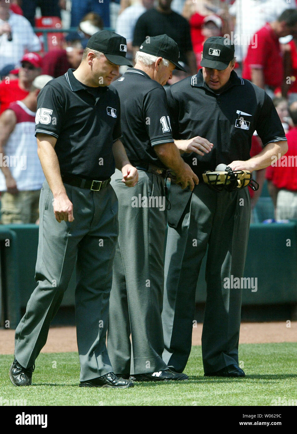 Homeplate umpire Bill Miller (R) takes the baseballs from crew chief Joe Brinkman (C) as first base umpire Jeff Nelson looks on during a game between the St. Louis Cardinals and the New York Yankees at Busch Stadium in St. Louis on June 12, 2005. Miller replaced Derryl Cousins who left the game with heart problems.  (UPI Photo/Bill Greenblatt) Stock Photo
