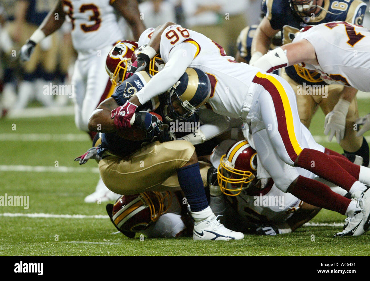 The Washington Redskins defense led by Lemar Marshall (98) pushes St. Louis Rams running back Steven Jackson back during the third quarter at the Edward Jones Dome in St. Louis on December 4, 2005. Washington held Jackson to 24 yards rushing, defeating St. Louis, 24-9.  (UPI Photo/Bill Greenblatt) Stock Photo