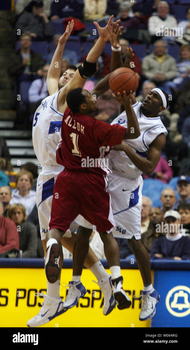 Saint Louis University's Danny Brown (R) and Ian Vouyoukas (L) try to block the shot by Saint Joseph's Abdulai Jalloh in the first half at the Savvis Center on January 25, 2006. (UPI Photo/Bill Greenblatt) Stock Photo