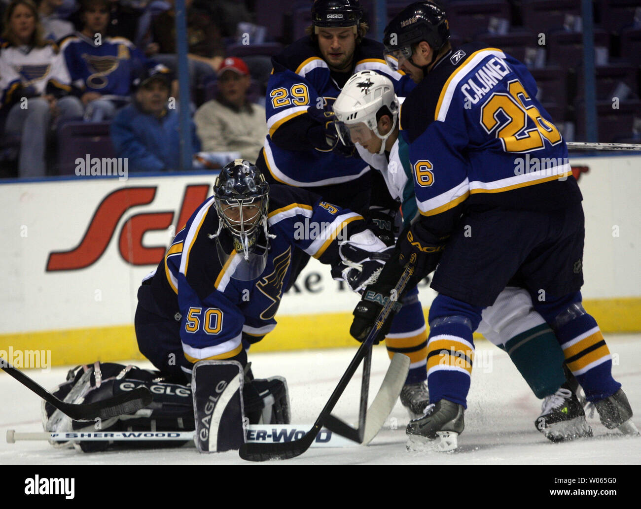 San Jose Sharks Marcel Goc (C) is slowed by St. Louis Blues Jeff Woywitka (29) and Petr Cajanek (26) as Blues goaltender Reinhard Divis knocks the puck clear in the first period at the Savvis Center in St. Louis on March 21, 2006.  (UPI Photo/Bill Greenblatt) Stock Photo