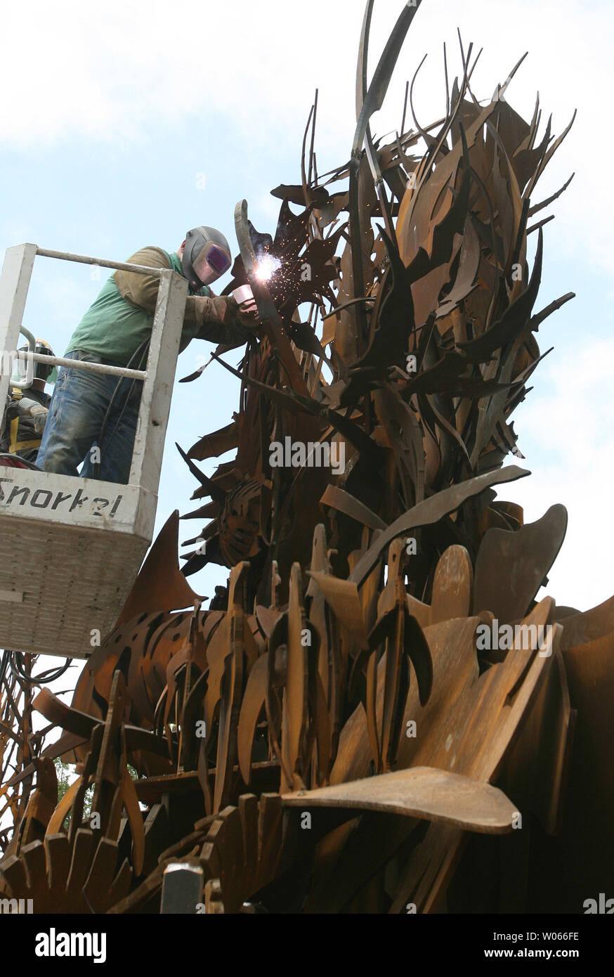 A workman welds metal pirces together during the installation of the ...