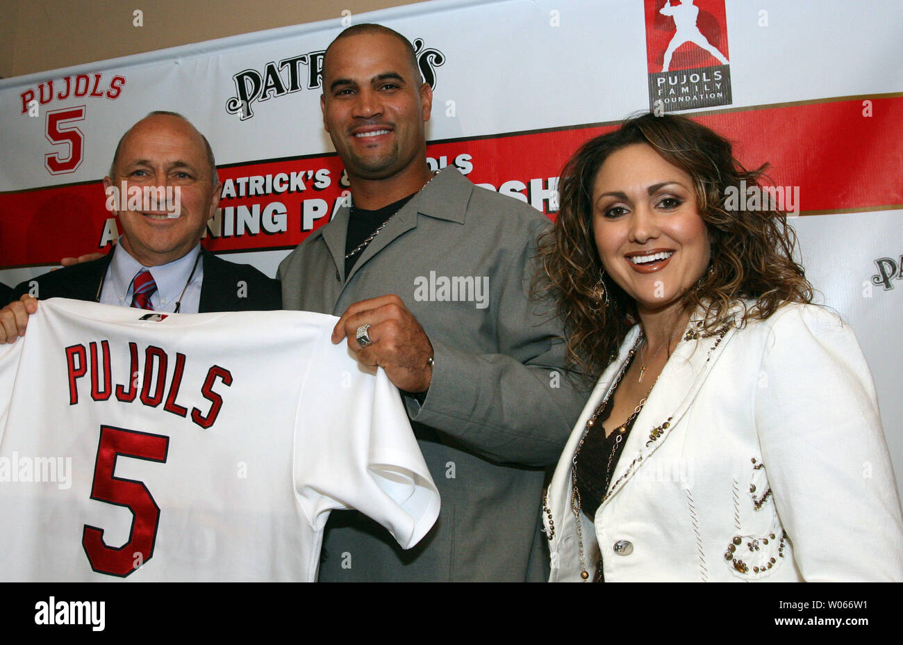 St. Louis Cardinals Albert Pujols (C) along with wife Deidre and Hanon Management Group's Patrick Hanon, pose for a photograph after announcing the partnership of a group that will open a resturant in the fall called PUJOLS FIVE, in the Westport area of St. Louis on June 1, 2006. The Pujols' hope that the resturant will help fund the Pujols Family Foundation, the couples 501C3 organization. (UPI Photo/Bill Greenblatt) Stock Photo