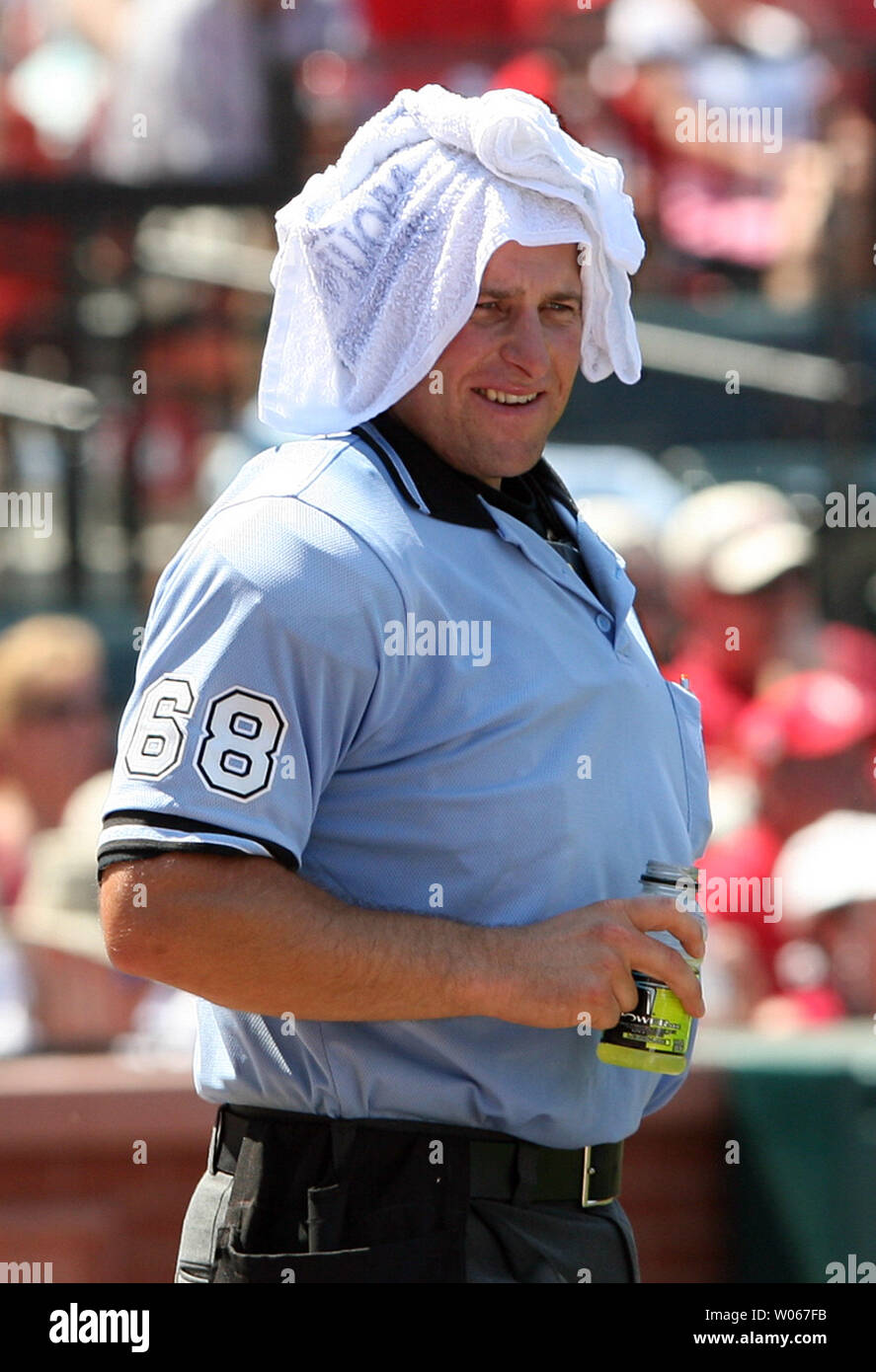 Homeplate umpire Chris Guccione tries to stay cool with a cold towel and a drink in between innings of a game between the Los Angeles Dodgers and the St. Louis Cardinals at Busch Stadium in St. Louis on July 16, 2006. With a high temperature of 98 degrees and a heat index of 105, many fans were overcome by the heat. (UPI Photo/Bill Greenblatt) Stock Photo