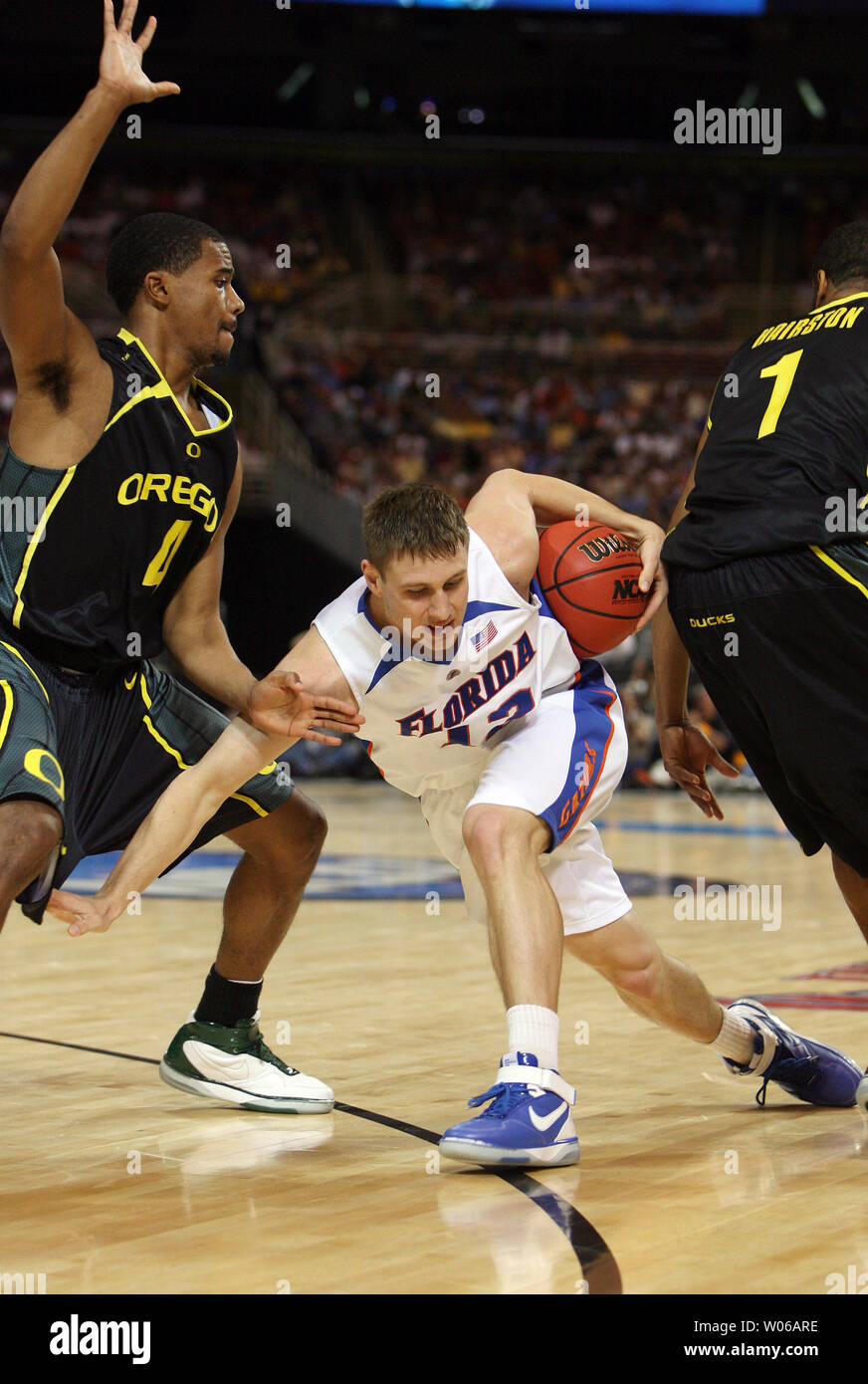 Florida Gators Lee Humphrey (C) runs the basketball past Oregon Ducks Aaron  Brooks (L) and Malik Hairston towards the basket in the first half of the  NCAA Midwest Regional at the Edward