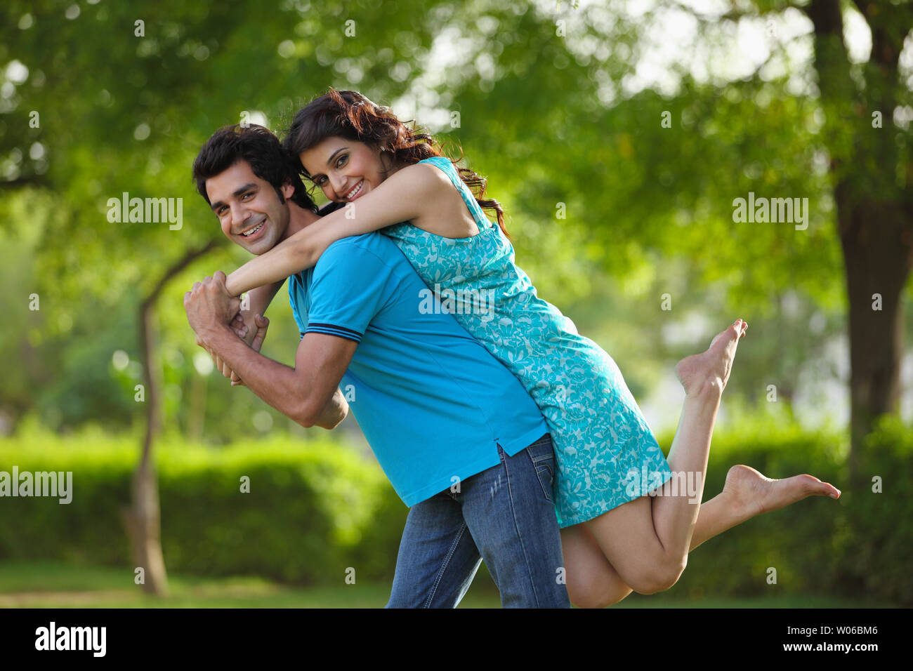 Couple playing piggyback ride in park Stock Photo - Alamy