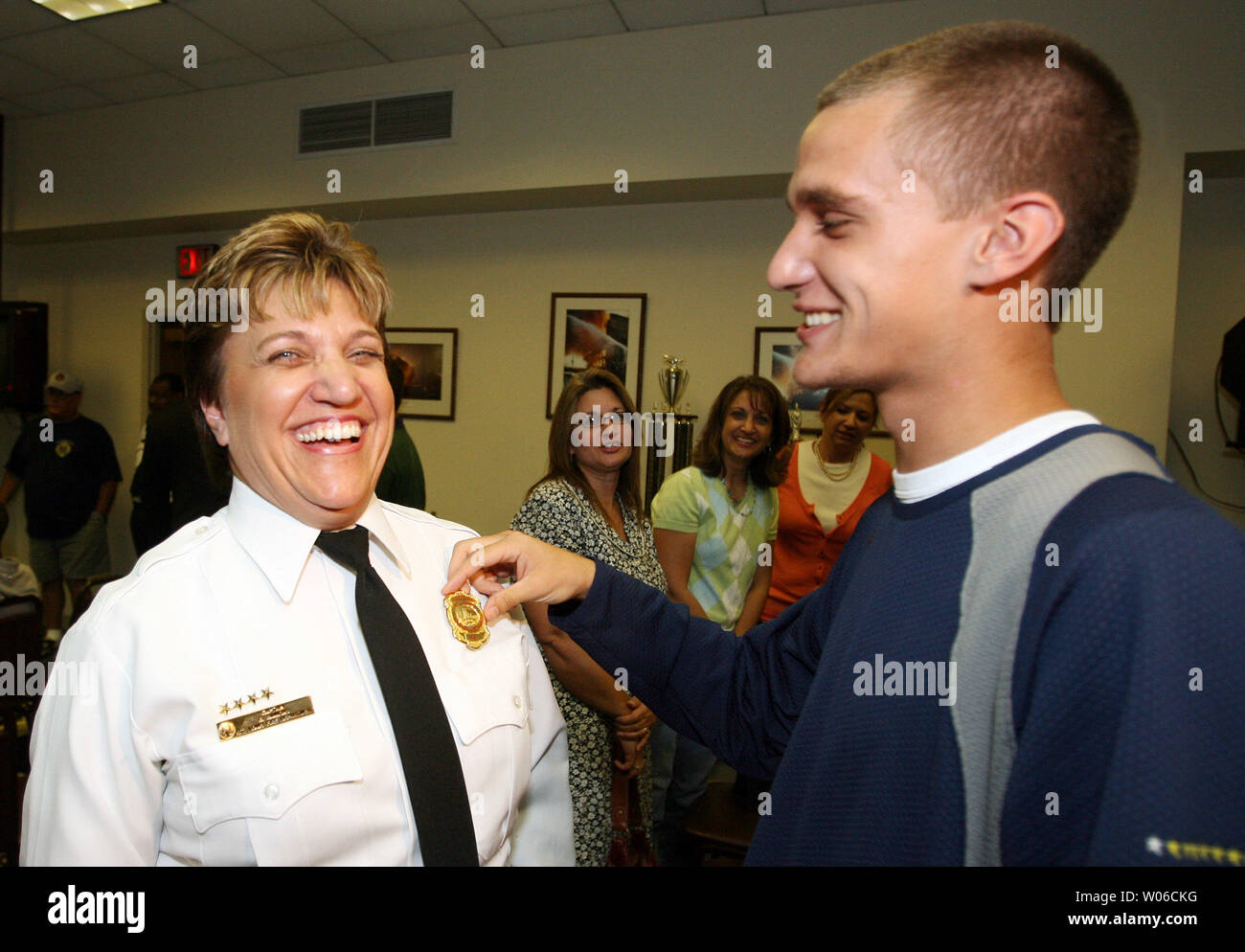 Newly appointed St. Louis Fire Department Battalion Chief Gail Simmons has her badge pinned on by her son David following ceremonies in St. Louis on October 2, 2007. Simmons is the first female in the 150 history of the department to make it to the rank of battalion chief.  (UPI Photo/Bill Greenblatt) Stock Photo