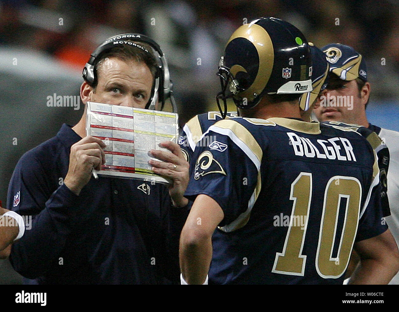 St. Louis Rams head football coach Scott Linehan (L) covers his mouth as he  talks with coachs while quarterback Marc Bulger waits for instructions in  the last minute of a game against