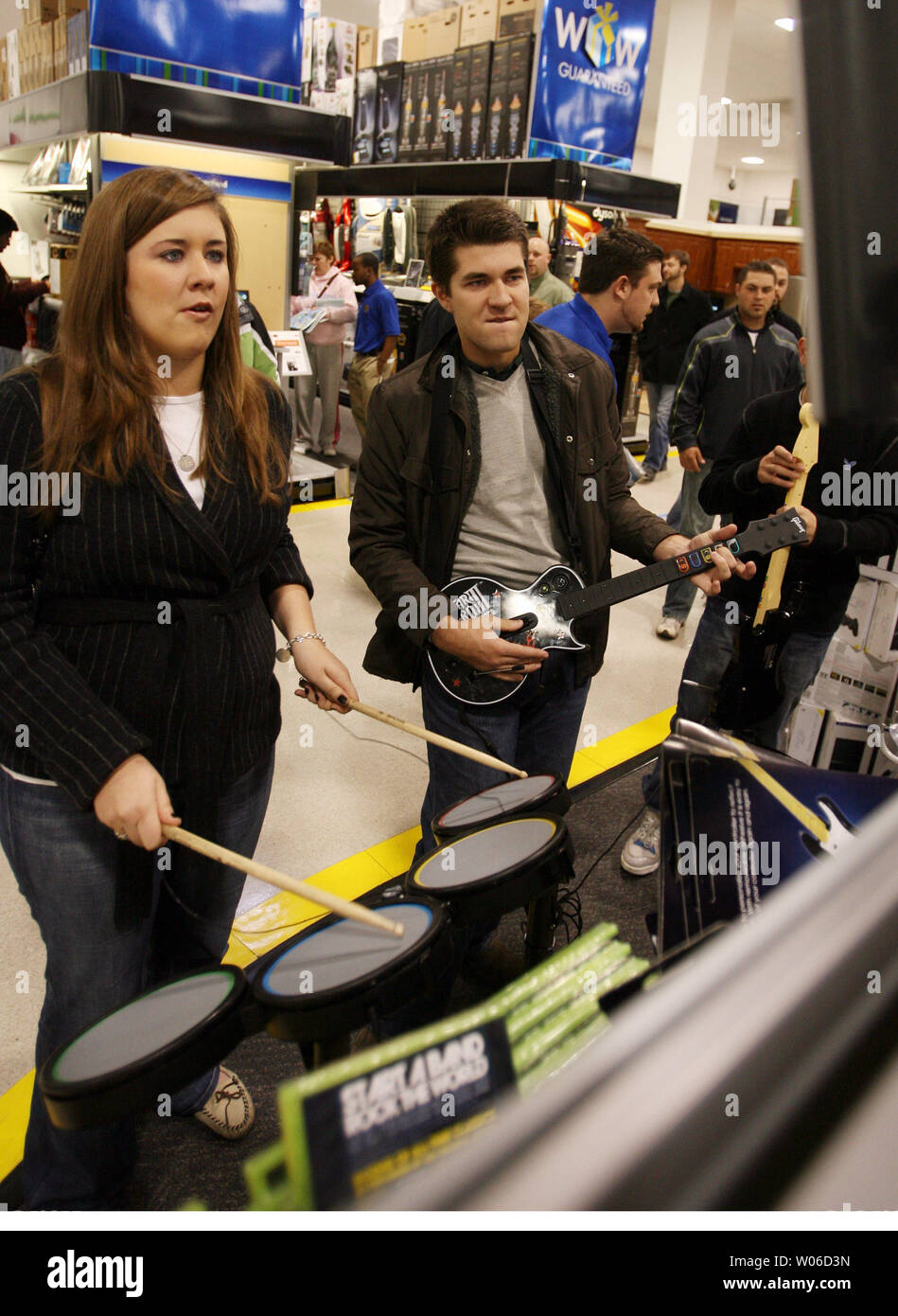 Spencer and Katie Koch try out the Rock Band video game on the XBOX 360  system as they shop at the Best Buy store in Richmond Heights, Missouri on  November 23, 2007.