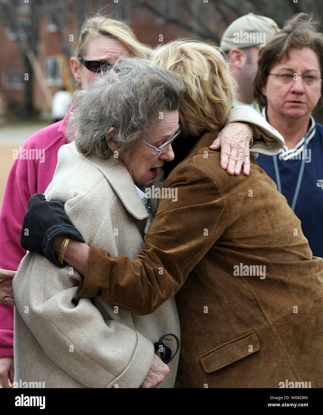 Family members of a dead Kirkwood police officer hug outside of the