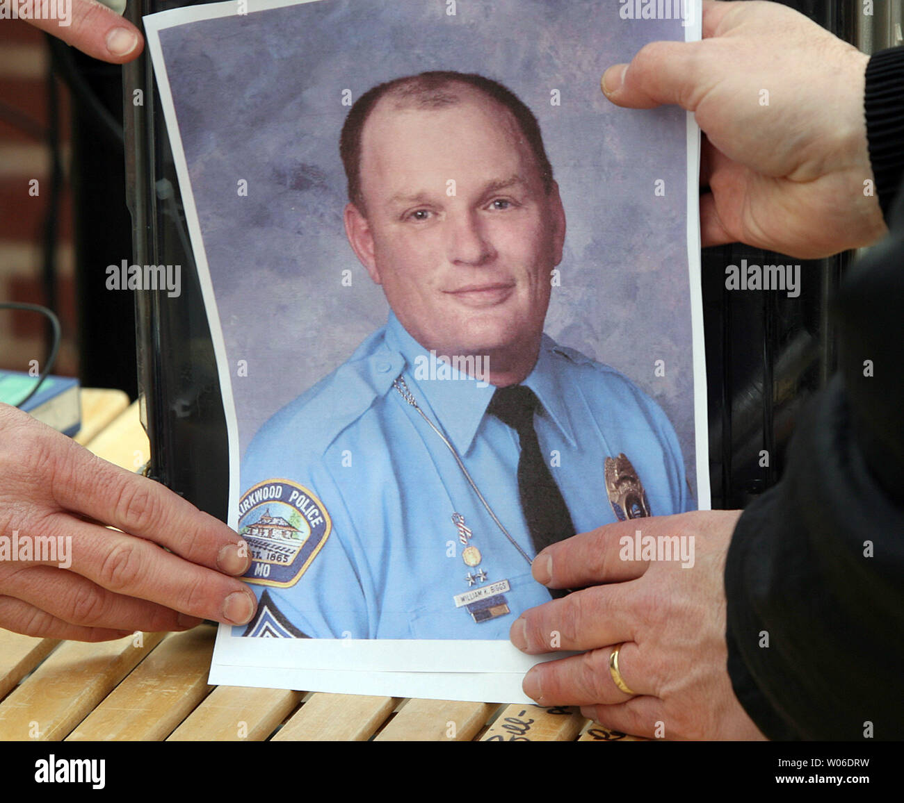 Television crews hold a photo of Kirkwood Police Sgt. William Biggs