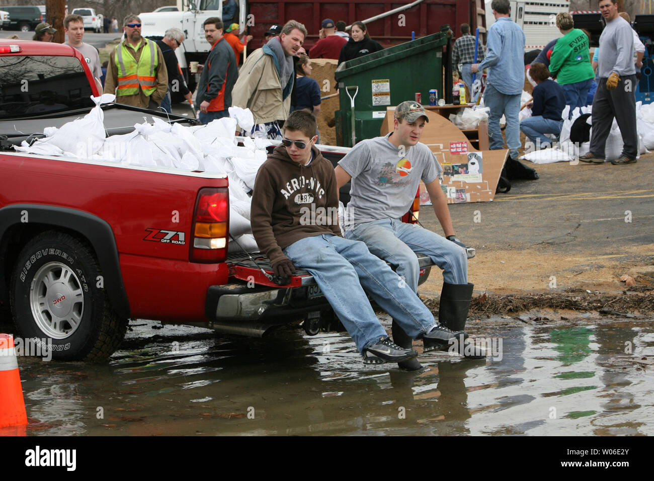 Volunteers sit on the back of a pickup truck, full of sandbags that will be placed next to a building to protect from rising flood waters of the Meramec River in Fenton, Missouri on March 21, 2008. Sixteen people have been killed by Midwest flooding after heavy rains hit the areas earlier in the week. (UPI Photo/Bill Greenblatt) Stock Photo