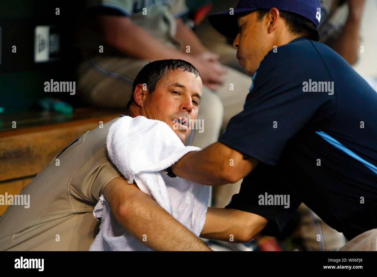San Diego Padres pitcher Greg Maddux (L) tries to cool down with cold towels during a game