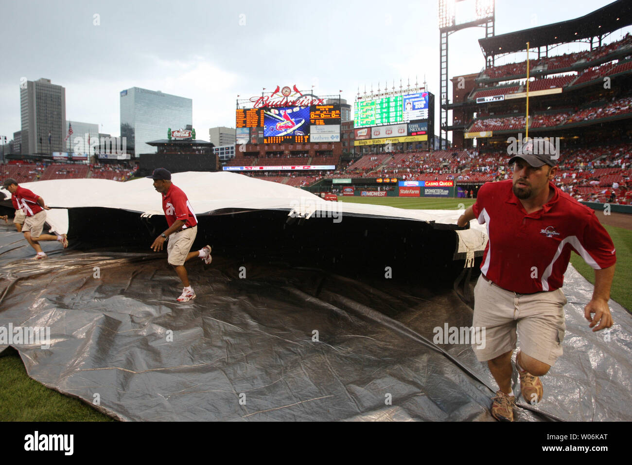 Busch Stadium field crew members run to spread the tarp across the infield as rain falls during the sixth inning of the San Diego Padres-St. Louis Cardinals baseball game at Busch Stadium in St. Louis on August 16, 2009.   UPI/Bill Greenblatt Stock Photo