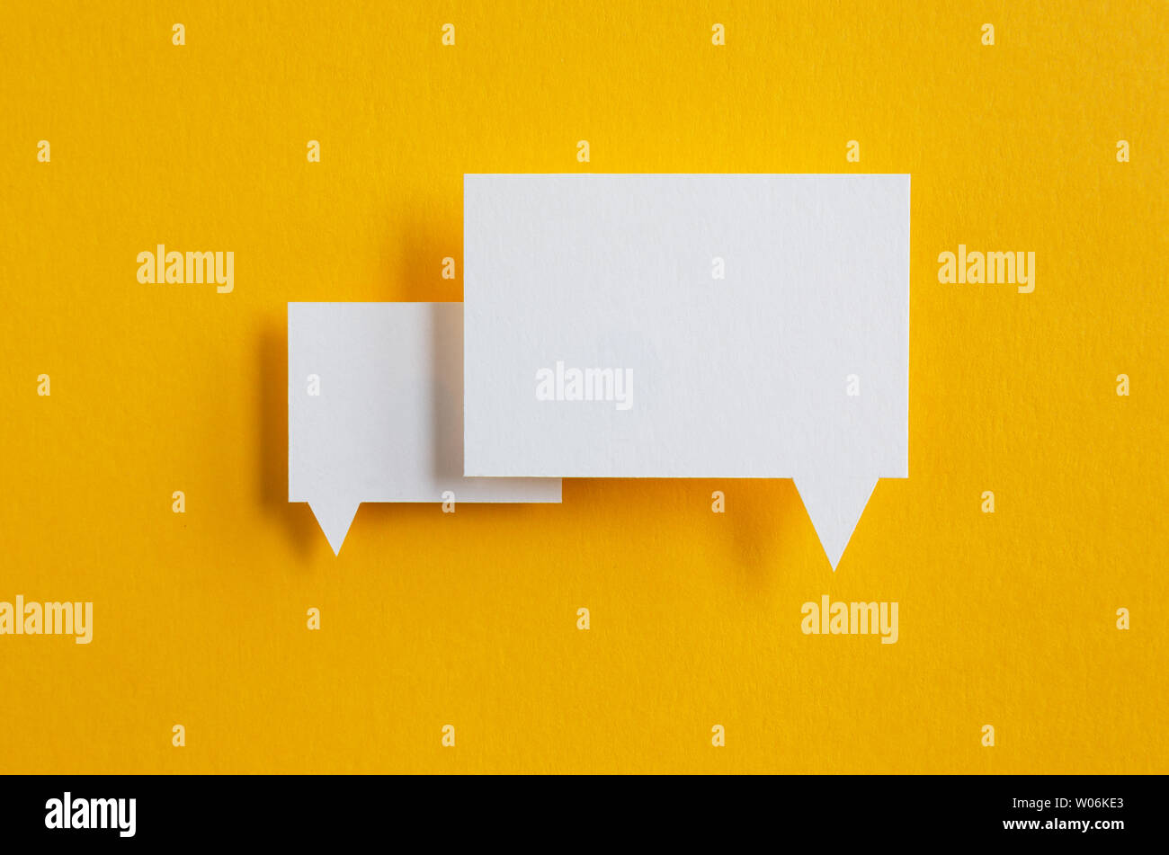 paper speech bubbles on yellow background Stock Photo - Alamy