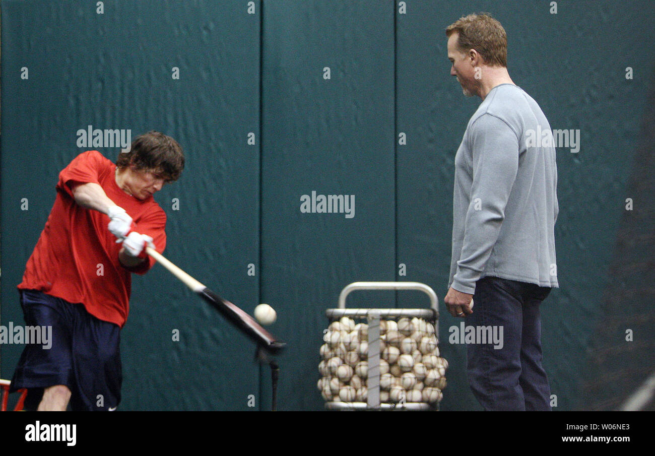 St. Louis Cardinals hitting coach Mark McGwire (R) gives centerfielder