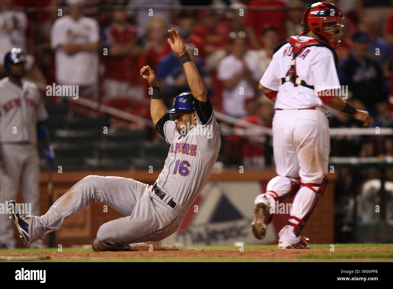 New York Mets Angel Pagan (L) slides safely into home plate with the go ahead run in the 20th inning against the St. Louis Cardinals at Busch Stadium in St. Louis on April 17, 2010.  Pagan scored from third base on a sacrifice fly ball by Jose B. Reyes as New York won the nearly seven hour game, 2-1.    UPI/Bill Greenblatt Stock Photo