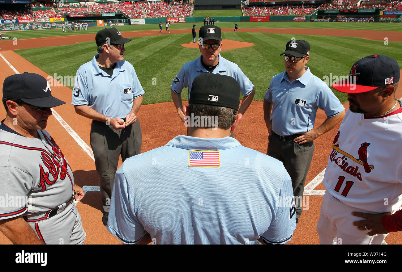 Home plate umpire Chris Guccione checks the lineups before the Atlanta Braves - St. Louis Cardinals baseball game at Busch Stadium in St. Louis on September 11, 2011.  Umpires, coaches and players are all wearing American flag decals on their backs to remember the attacks of September 11, 2001. UPI/Bill Greenblatt Stock Photo