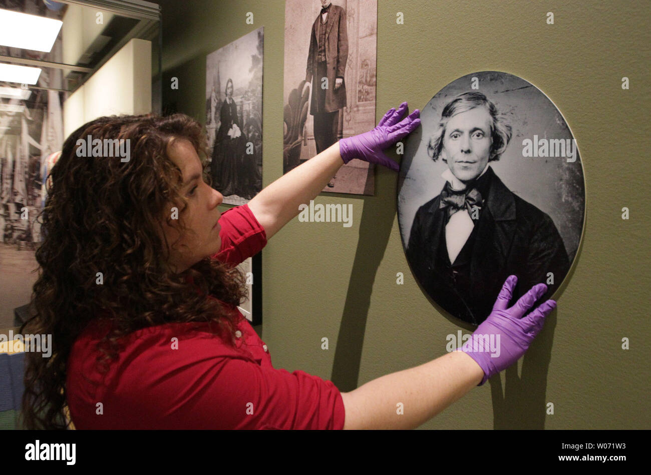 Catlin Carter a Conservation Lab Technician at the Missouri History Museum straightens a photograph of William Greenleaf Eliot as the 'Civil War in Missouri,' display continues to set up at the Museum in St. Louis on November 8, 2011. To commemorate the sesquicentennial of the Civil War the Missouri History MuseumÕs comprehensive The Civil War in Missouri will feature items from America's bloodiest conflict. UPI/Bill Greenblatt Stock Photo