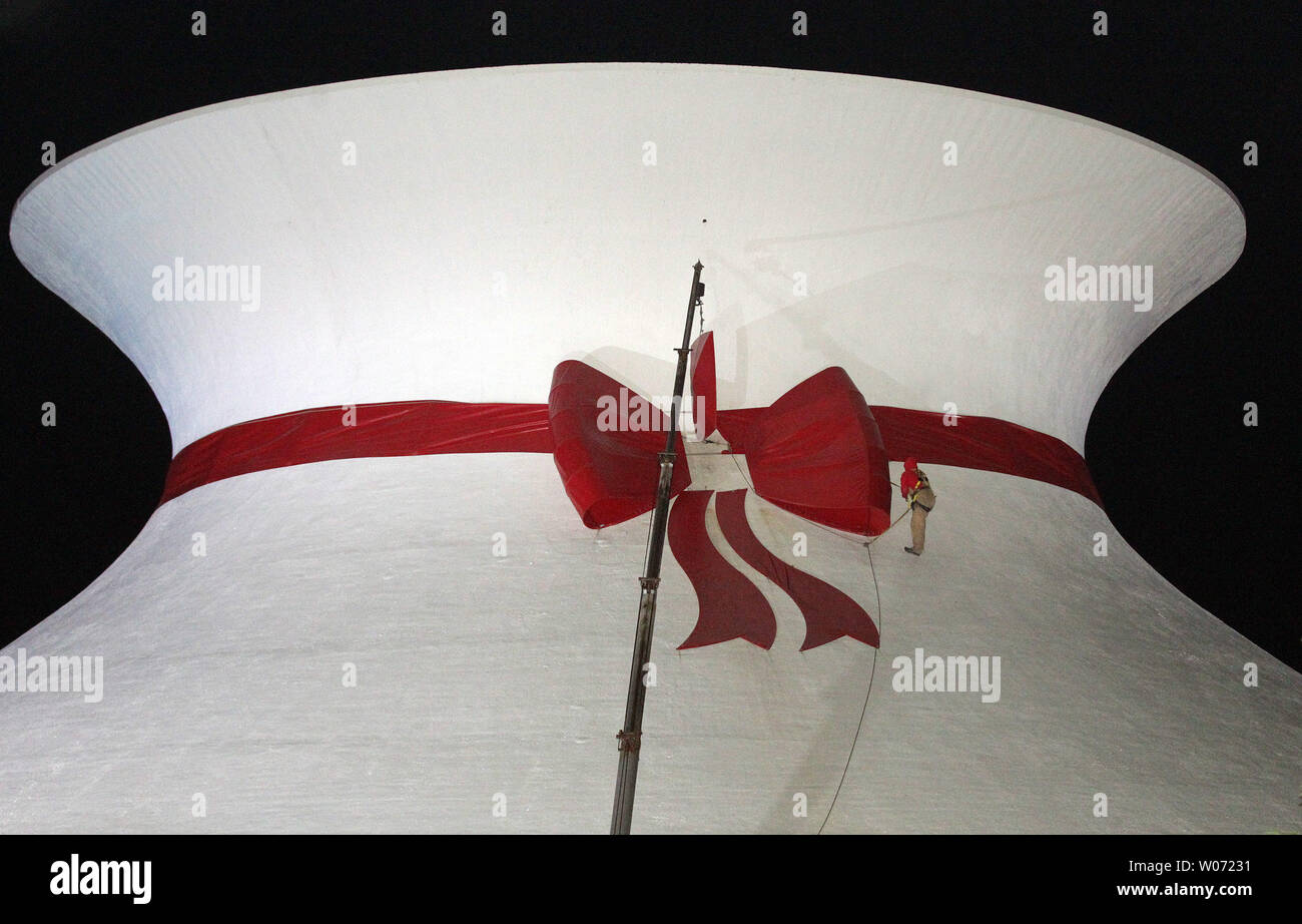Greg Sanders from Advanced Sign and Lighting, adjusts the bow on the red ribbon during installation on the Planetarium at the St. Louis Science Center in Forest Park in St. Louis on November 17, 2011.The now famous red ribbon that decorates the Planetarium each holiday season was actually instigated as a prank by Washington University students in 1966. On a December evening, a group of architecture students scaled the building and left the ribbon on the recognizable hyperboloid curve of the Planetarium building. The ribbon will remain until January 2, 2012.    UPI/Bill Greenblatt Stock Photo