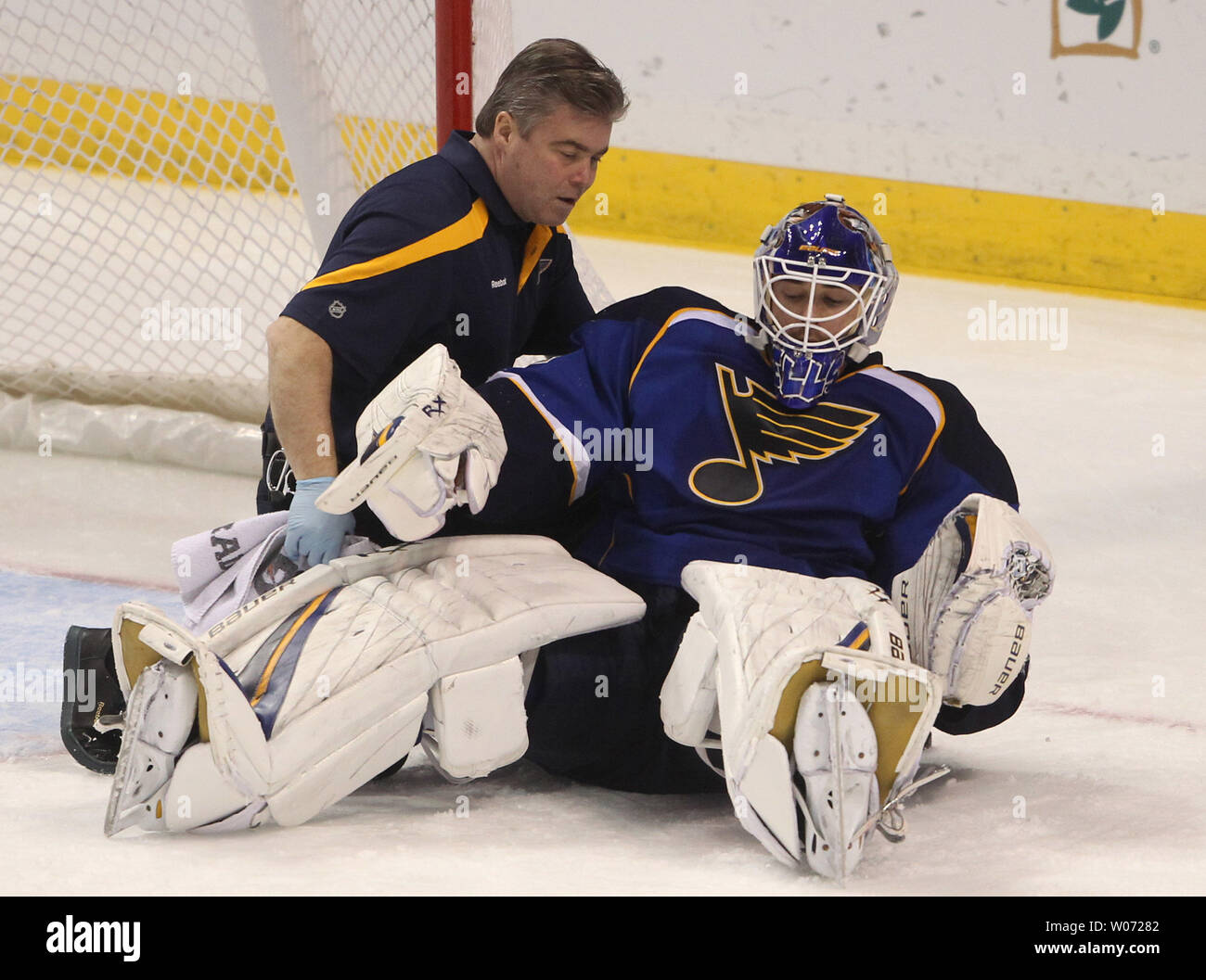 St. Louis Blues trainer Ray Barile helps goaltender Brian Elliott back up after Detroit Red Wings Justin Abedlkader charged into him in the third period at the Scottrade Center in St. Louis on December 6, 2011.  St. Louis won the game 3-2.    UPI/Bill Greenblatt Stock Photo