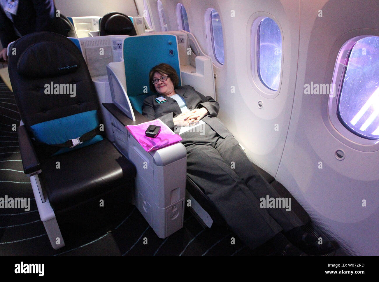 Boeing employee Kimberly Forkan tries out the seat turned bed in business  class of a Boeing 787 Dreamliner at Lambert -St. Louis International  Airport during a media tour in St. Louis on