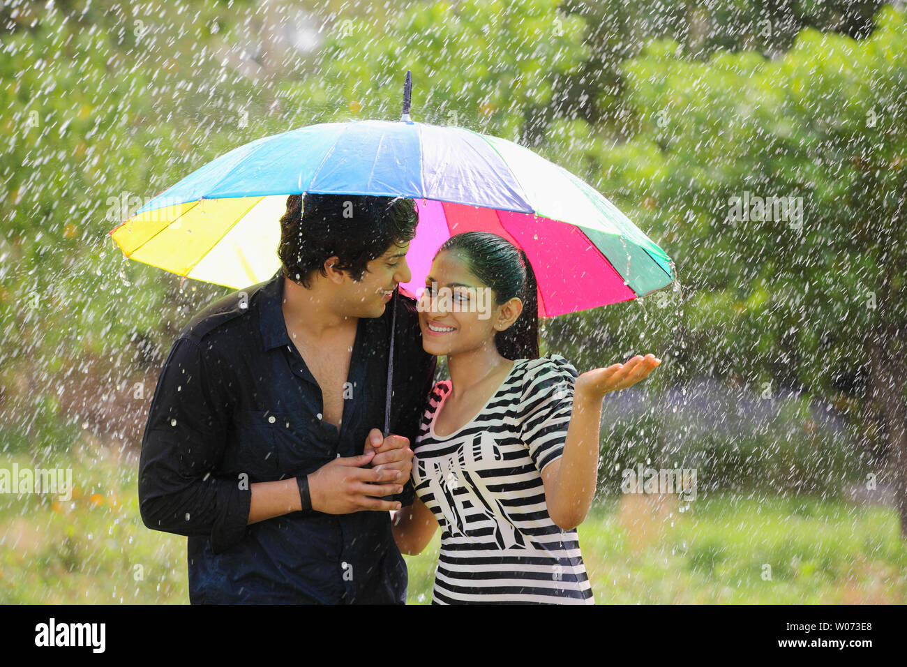 Indian couple under an umbrella in the rain Stock Photo Alamy